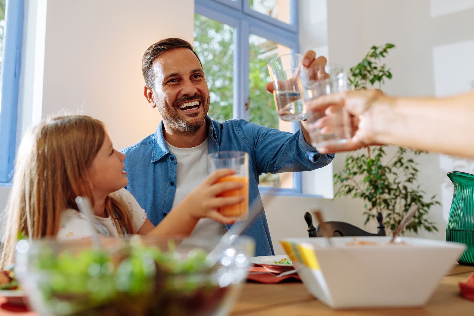Father and daughter enjoying clean water in kitchen