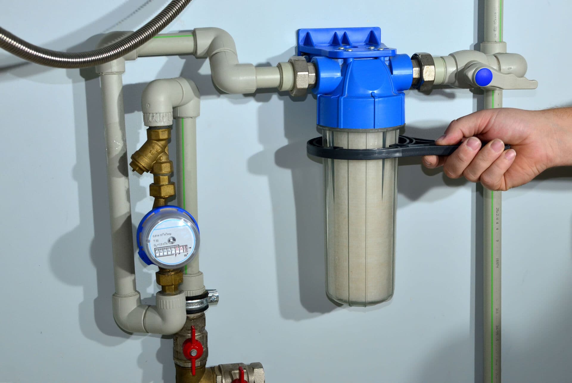 Wall-mounted water filtration system with flow meter