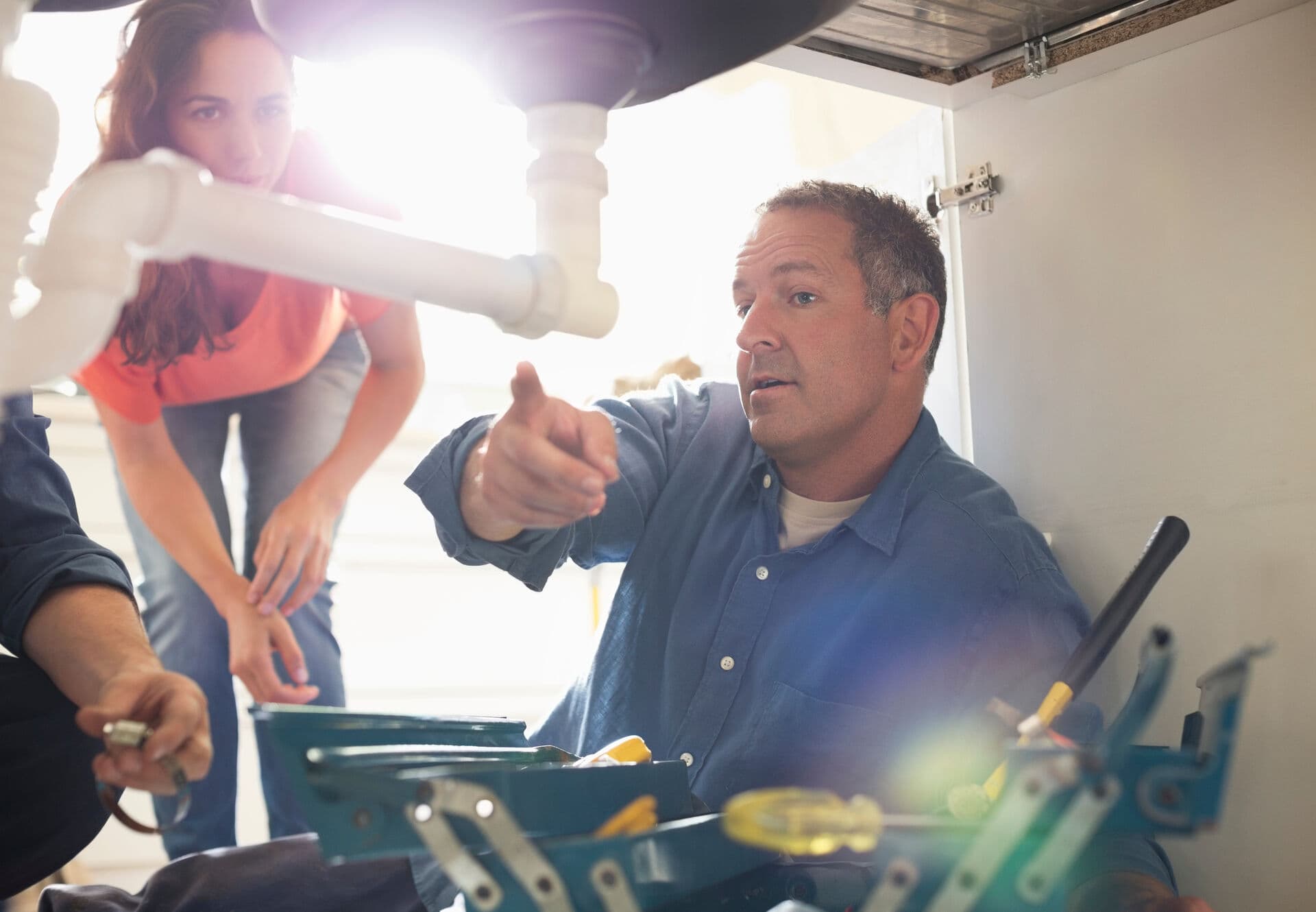 Plumber explaining under-sink water system to homeowner
